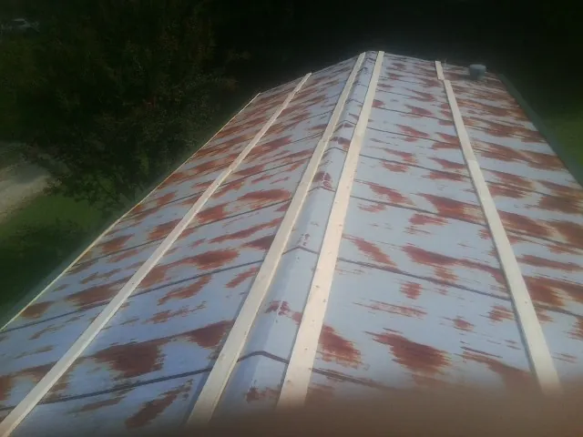 Rusted metal roof panels with new wood purlins before replacement — Storm Damage Roof Repair in Loganton by Roofing Brothers